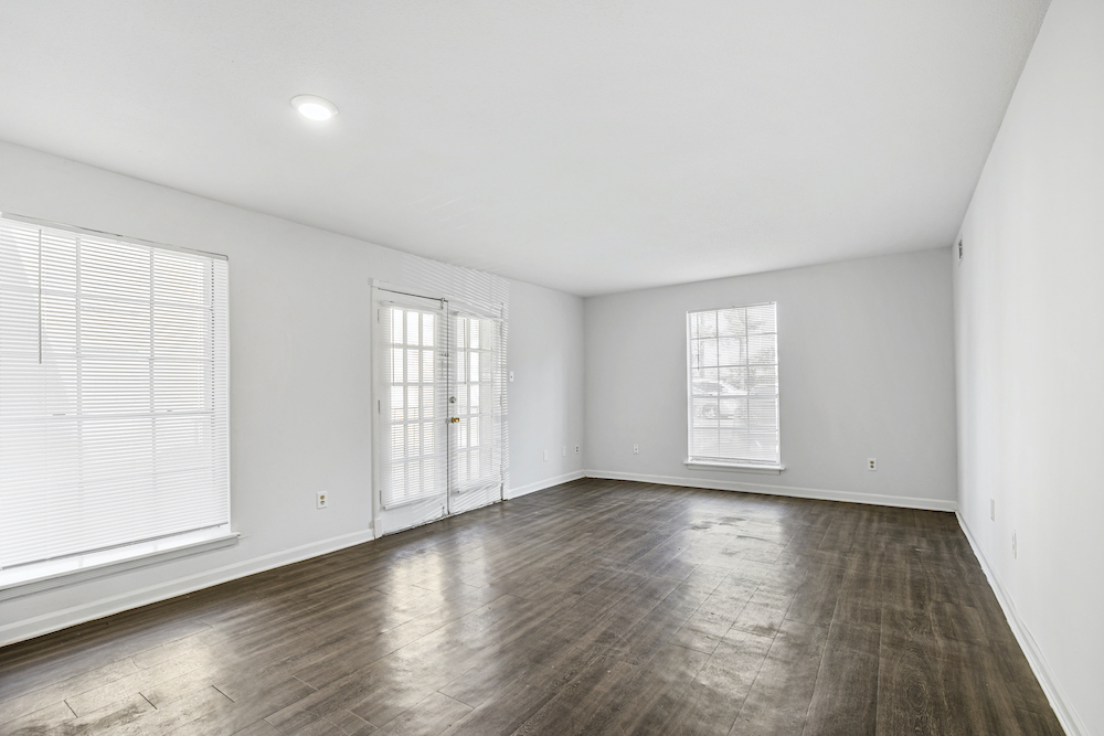 unfurnished living area with large windows and wood-style flooring