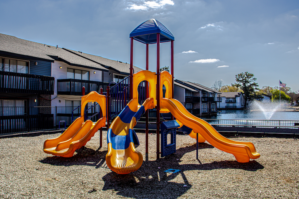 playground with multiple slides in front of apartment complex